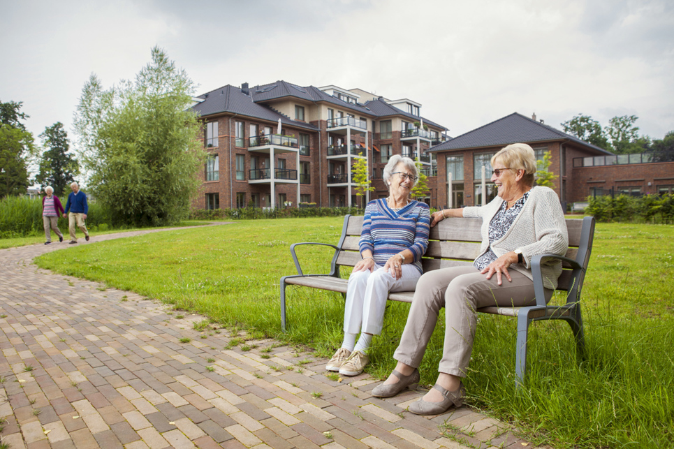 Vrouwen zitten op bankje voor woonzorgcentrum Adegeest